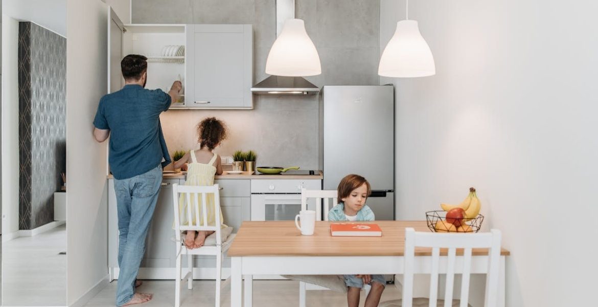 A father and children enjoying quality time in a bright, modern kitchen area.