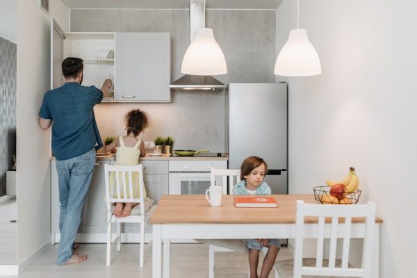 A father and children enjoying quality time in a bright, modern kitchen area.